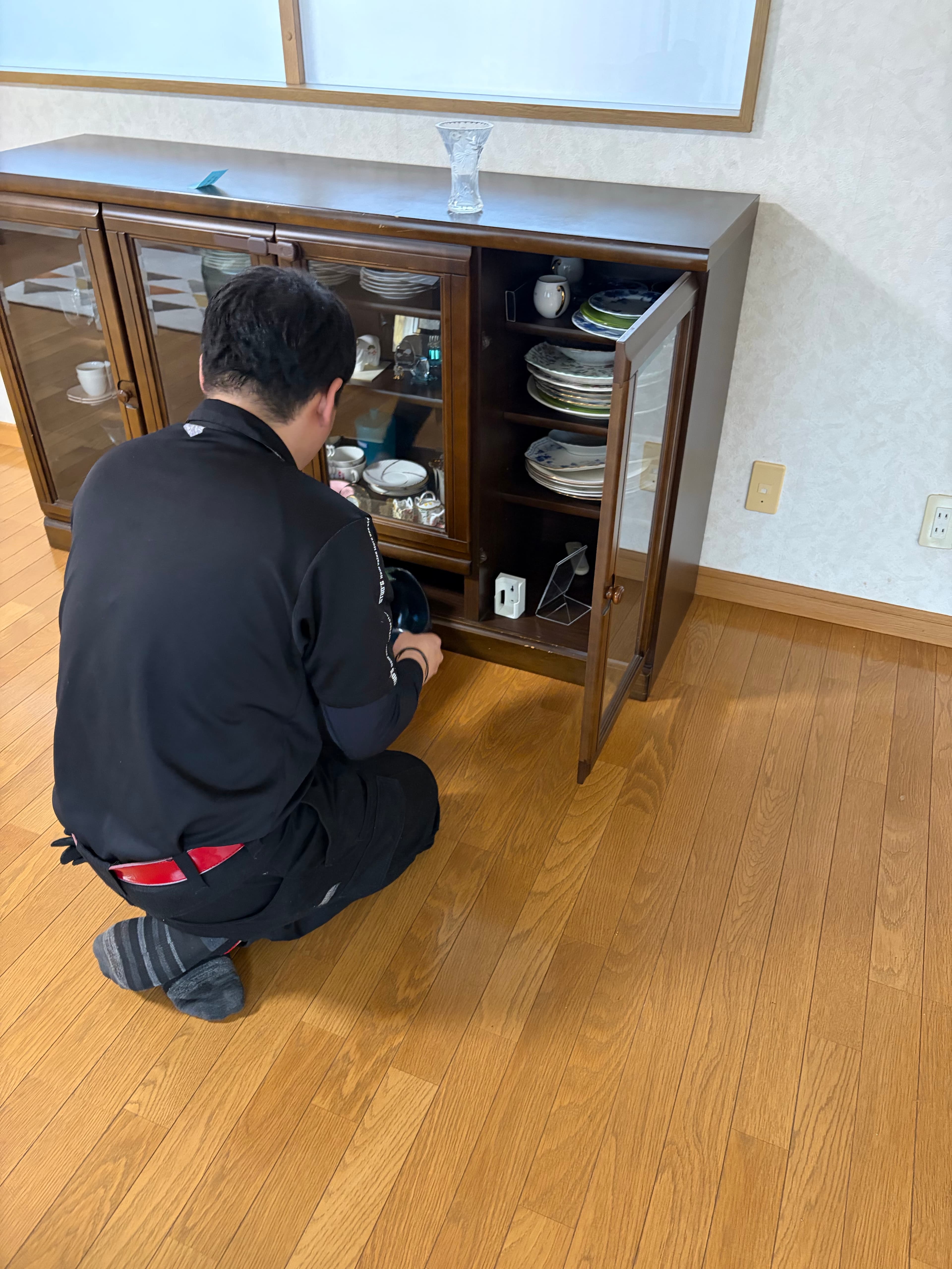 食器棚の前で遺品を丁寧に仕分ける作業の様子